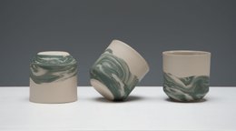 Dark green ceramic mug with swirling pattern.