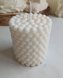  White, textured, house-shaped pillar candle with a cozy, festive appearance.