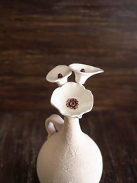  White ceramic vase with abstract floral design, featuring a single dried flower arrangement.
