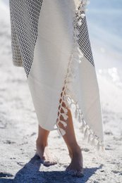 "Soft, absorbent cotton towels in a variety of pastel colors with hand-knotted fringes, perfect for use at the beach or poolside."