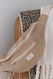Beige shoulder bag with leopard print lining and zipper details.