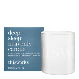 A tall, round, white candle with a label that says "This Works - Deep Sleep Heavenly Candle - 220 gr". The candle is scented and designed to promote deep sleep.