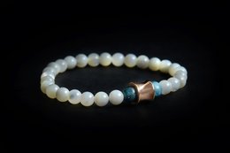 Elegant white beaded bracelet with blue and gold accents, suitable for casual or formal wear.