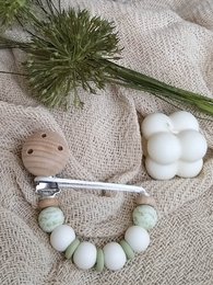 Newborn pacifier clip with leaf design, made of soft, safe materials for baby's comfort.