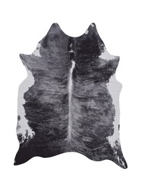 A large, rectangular black and white cowhide rug with a distinctive pattern and texture.