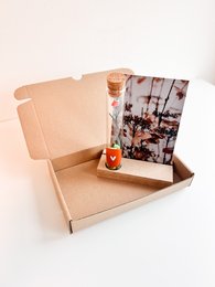 Gift box tube for making DIY bracelets. Includes colorful floral pattern and wooden beads for a creative kids' craft activity.