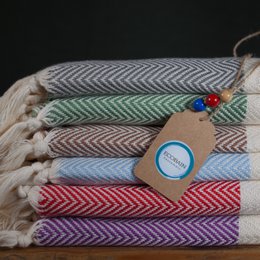 A set of 16 handwoven and knotted bath towels in a variety of colors, suitable for use on the terrace, deck chair, and for thermal baths.