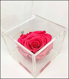 Fuchsia-colored eternal rose in a handmade glass cube, perfect for decorative display.