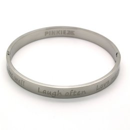 A silver-colored cuff bracelet with the text "Laugh often, love much" engraved on it. The bracelet appears to be part of the Pinkiezz jewelry line.