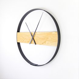 Oval-shaped wall clock with a black metal frame and a natural wood accent. Features a minimalist design that would complement a variety of home decor styles.