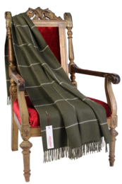  Green and brown plaid alpaca wool throw blanket with fringed edges, draped over a wooden armchair.