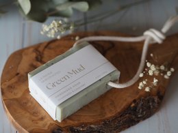 Green mud soap bar with natural rope for hanging. Rectangular shape, earthy green color.