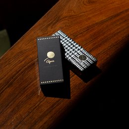 Long black scented matches in a sleek black box with a gold logo.