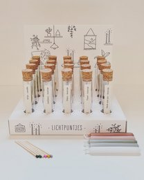 Assortment of bright, colorful candles in various shapes and sizes, including round, tall candles in a display set.