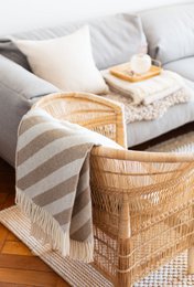  Beige and white striped wool blanket with fringe, suitable for use as a throw on a couch or bed.