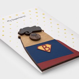  3D wooden superhero greeting card with handmade hero figure, blue red cape, gold chest emblem, wooden details