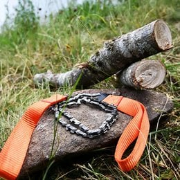 Portable camping saw with orange strap, manual wood cutting tool for outdoor adventures