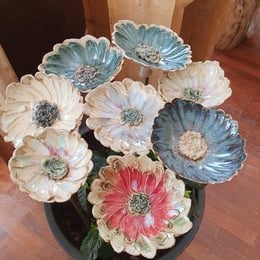 Colorful ceramic garden stakes with unique blossom designs, made of stoneware, suitable as gifts for weddings, birthdays, or home decor.