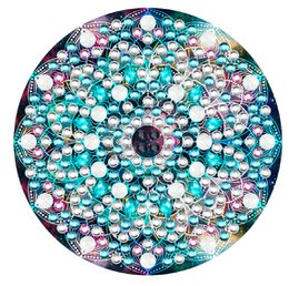  A round mirror with a decorative diamond painting design featuring a variety of colorful gems and crystals in shades of turquoise, pink, and white.
