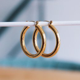  Gold-tone stainless steel hoop earrings with a pearl accent, measuring approximately 40mm in diameter. Suitable for statement fashion.