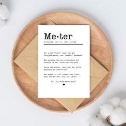A simple, minimalist greeting card with the word "Meter" printed in bold text. The card appears to be made of high-quality paper or cardstock and is placed on a soft, textured fabric background.