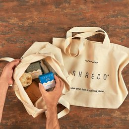 Beige cotton tote bag with "SHAECO" logo and text "Love your life, love the planet."
