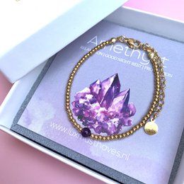 Amethyst and stainless steel beaded bracelet in silver/gold tones.