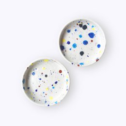 Set of 4 round coasters with a confetti-like pattern of colorful speckles in various shades of blue, yellow, and pink.