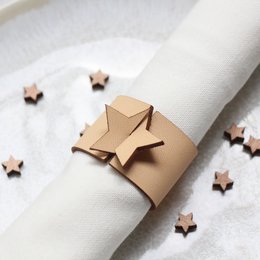 Set of 4 natural leather napkin rings with star-shaped accents. Suitable for formal or casual table settings.