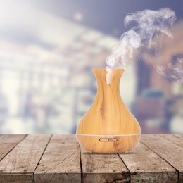 Light wood aroma diffuser with essential oil mist and automatic shut-off feature.