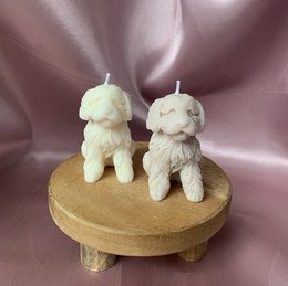 Soft, plush candles in the shape of two adorable poodle dogs, available in natural/light beige, light brown, brown, and gray colors. These unique candles would make a charming addition to any home decor or as a thoughtful gift.