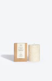 Tall, round, white candle with a textured surface and a natural, earthy aesthetic. Made of soy wax and infused with a calming, herbal scent.