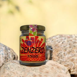 Organic ginger powder in a glass jar with a vibrant red and orange label featuring the word "Zenzero" and a floral design.