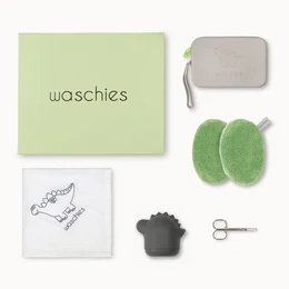 A green gift box containing baby bath foam in grey, pastel blue, and pastel yellow colors, along with a soft green bath sponge and a baby-themed towel.