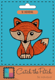 Brooch featuring a cute, stylized brown fox design. The brooch has a vibrant, whimsical appearance with a playful, cartoon-like fox illustration.
