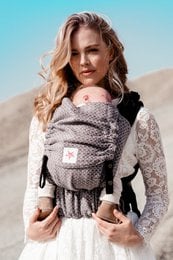 Gray baby carrier with heart-shaped pattern, adjustable straps, and padded back support for comfortable babywearing.