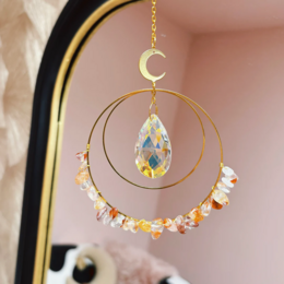 Elegant gold-toned dreamcatcher pendant with a large teardrop-shaped moonstone crystal and colorful gemstone accents, evoking a feminine, mystical energy.