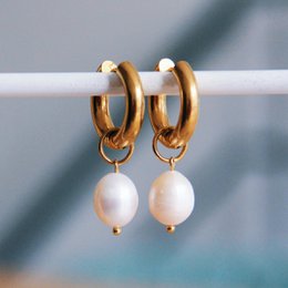  Gold-tone hoop earrings with large freshwater pearls, creating a statement accessory.
