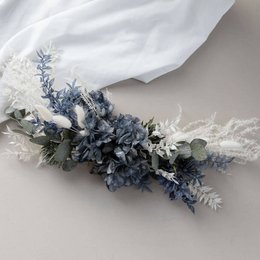 Dried flower arrangement featuring eucalyptus and blue flowers on an easel. Includes a variety of colors, textures, and shapes.