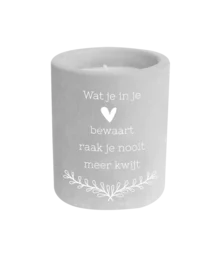 A round, tall cement candle with the text "Wat je in je hart bewaart, raak je nooit kwijt" (What you keep in your heart, you never lose) printed on it.