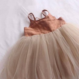 A beige and peach tulle dress with a satin bodice and straps. The dress has a full, layered tulle skirt that creates a voluminous, feminine silhouette.