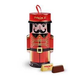 A red and black metal box with a nutcracker-style figure on the front, containing 10 giandujas (chocolate-hazelnut confections). The box is labeled "The Groom Maxim's" and is categorized as a Chocolate Gift.