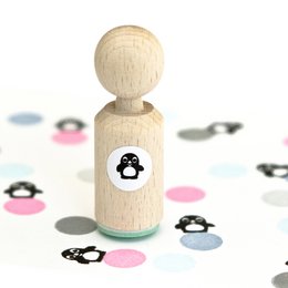 A small, round wooden stamp with a penguin icon printed on it. The stamp is suitable for crafting, scrapbooking, or decorative purposes.
