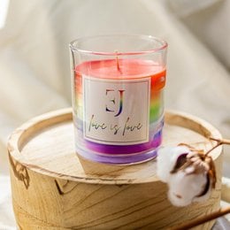 Colorful rainbow-themed scented candle with "Love is love" text on the label.
