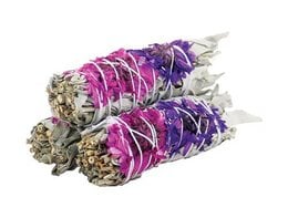 Sage incense sticks in purple and pink colors, wrapped in a spiral pattern. The incense sticks have a natural, earthy appearance with dried herbs and flowers visible.