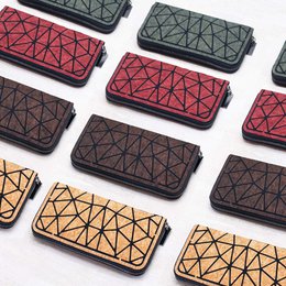 Geometric cork zipper wallet in multiple colors including natural, turquoise, burgundy, and brown. Features a unique triangular pattern design.