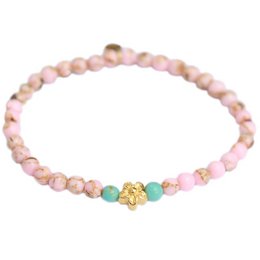 A delicate pink stone bracelet with a gold flower charm, perfect for adding a touch of elegance to any outfit.