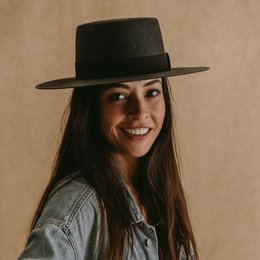 Black boater hat with wide brim, made of straw material, suitable for casual or formal wear.