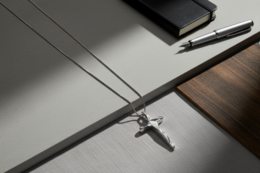 Elegant cross-shaped pendant necklace in gold and silver tones, featuring a sleek and minimalist design. Suitable for everyday wear or special occasions.