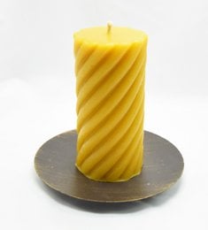 Handmade beeswax pillar candle, 5.3 inches tall, with a spiral pattern, in a warm yellow color.